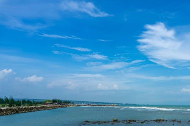 Endonezya, Tuban 'da açık bir gündüz vakti gökyüzü altında çarpıcı kayalık çıkıntıları olan canlı mavi okyanus.