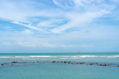Endonezya, Tuban 'da açık bir gündüz vakti gökyüzü altında çarpıcı kayalık çıkıntıları olan canlı mavi okyanus.
