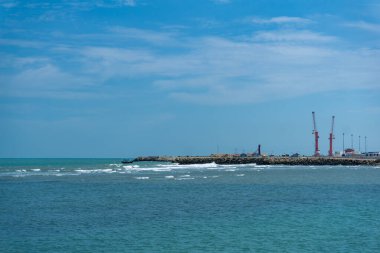 Endonezya, Tuban 'da açık bir gündüz vakti gökyüzü altında çarpıcı kayalık çıkıntıları olan canlı mavi okyanus.