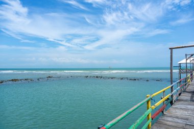 Endonezya, Tuban 'da açık bir gündüz vakti gökyüzü altında çarpıcı kayalık çıkıntıları olan canlı mavi okyanus.