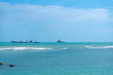 Endonezya, Tuban 'da açık bir gündüz vakti gökyüzü altında çarpıcı kayalık çıkıntıları olan canlı mavi okyanus.