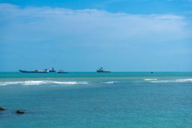 Endonezya, Tuban 'da açık bir gündüz vakti gökyüzü altında çarpıcı kayalık çıkıntıları olan canlı mavi okyanus.