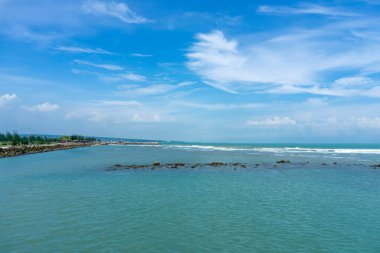 Endonezya, Tuban 'da açık bir gündüz vakti gökyüzü altında çarpıcı kayalık çıkıntıları olan canlı mavi okyanus.