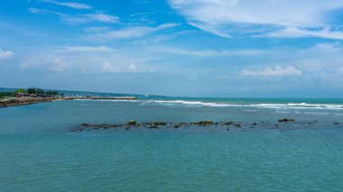 Endonezya, Tuban 'da açık bir gündüz vakti gökyüzü altında çarpıcı kayalık çıkıntıları olan canlı mavi okyanus.