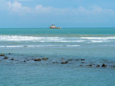 Endonezya, Tuban 'da açık bir gündüz vakti gökyüzü altında çarpıcı kayalık çıkıntıları olan canlı mavi okyanus.