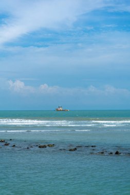 Endonezya, Tuban 'da açık bir gündüz vakti gökyüzü altında çarpıcı kayalık çıkıntıları olan canlı mavi okyanus.