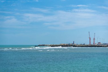 Endonezya, Tuban 'da açık bir gündüz vakti gökyüzü altında çarpıcı kayalık çıkıntıları olan canlı mavi okyanus.