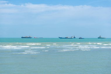 Endonezya, Tuban 'da açık bir gündüz vakti gökyüzü altında çarpıcı kayalık çıkıntıları olan canlı mavi okyanus.