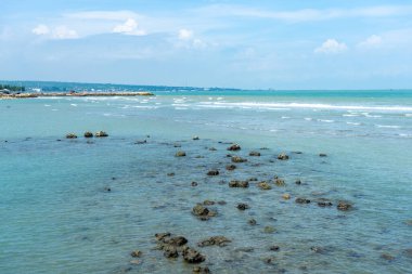 Endonezya, Tuban 'da açık bir gündüz vakti gökyüzü altında çarpıcı kayalık çıkıntıları olan canlı mavi okyanus.
