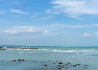Endonezya, Tuban 'da açık bir gündüz vakti gökyüzü altında çarpıcı kayalık çıkıntıları olan canlı mavi okyanus.