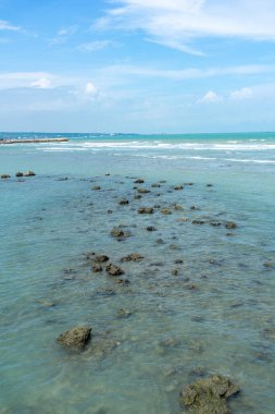 Endonezya, Tuban 'da açık bir gündüz vakti gökyüzü altında çarpıcı kayalık çıkıntıları olan canlı mavi okyanus.