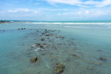 Endonezya, Tuban 'da açık bir gündüz vakti gökyüzü altında çarpıcı kayalık çıkıntıları olan canlı mavi okyanus.