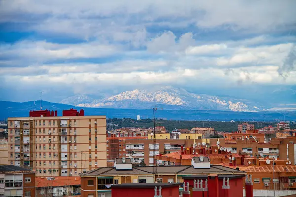 Madrid şehrinin silueti bulutlu gökyüzü ve arka planda Sierra dağları