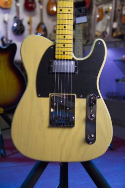 Katı, kahverengi bir elektro gitarın yakınında Humbucker pikapları, siyah yankesicileri ve gümüş donanımları var..