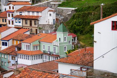Asturias balıkçı köyünün renkli yeşil imparatorluk evi Cudillero, bulutlu bir günde.