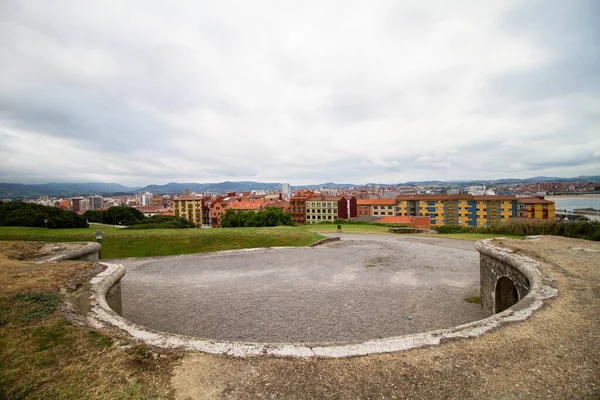 Cerro de Santa Catalina Cimadevilla Gijon, bulutlu arka planı olan bir kasaba.