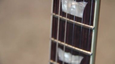 Güneş ışığı altında içi boş bir bedeni siyah-doğal kahverengi ahşap gitarla kaplayın. Humbucker pikaplı, yankesicisiz ve gümüşten donanımsız..