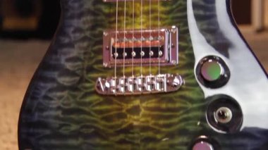 Su yeşilinden sarı elektro gitara, kamçılı, beyaz yankesicili ve gümüş donanımlı sağlam bir kaplan odununu kapat..