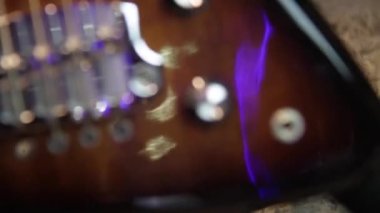 Güneş ışığı altında gitarı siyahtan kahverengiye yakın tut, Humbucker pikaplar, beyaz yankesiciler ve gümüş donanımlı.