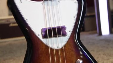 Güneş ışığı altında gitarı siyahtan kahverengiye yakın tut, Humbucker pikaplar, beyaz yankesiciler ve gümüş donanımlı.