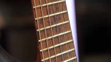 Yankesicisi ve siyah donanımı olmayan, humbucker pikaplı, katı kahverengi bir elektro gitarı kapat..