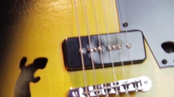 ブラックからナチュラルブラウンのウッドエレキギター サラマンダー型の穴 人間のバッカーピックアップ ブラックピックガードとシルバーハードウェア — ストック動画