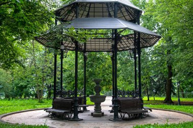 Kyiv 'deki Mariinsky Parkı' nda rahatlama tezgahları ve içme suyu için açık bir çardak.
