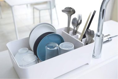 Mutfağın içindeki kutuda temiz tabak var.