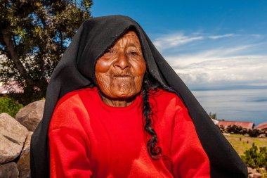 Taquile Adası 'ndan yetişkin bir kadın yolda dinleniyor. Titicaca Gölü 8 Mart 2017, Taquile Puno Peru.