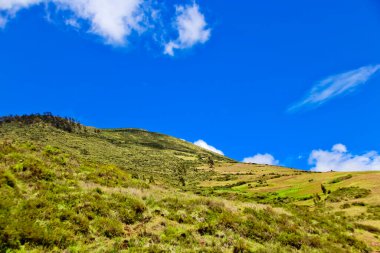 Dağları ve mavi gökyüzü olan güzel bir manzara.