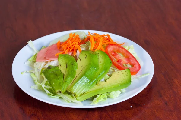 Kırmızı tabakta avokado salatası.