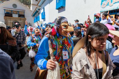 Geleneksel kostümlü dansçılar ve kalabalık Virgen del Carmen 'in şenliğini koreografilerle kutluyorlar. Temmuz 2023, Paucartambo. Cusco Peru.