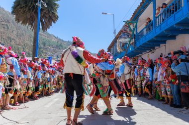 Geleneksel kostümlü dansçılar ve kalabalık Virgen del Carmen 'in şenliğini koreografilerle kutluyorlar. Temmuz 2023, Paucartambo. Cusco Peru.