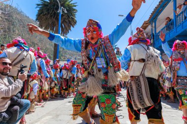 Geleneksel kostümlü dansçılar ve kalabalık Virgen del Carmen 'in şenliğini koreografilerle kutluyorlar. Temmuz 2023, Paucartambo. Cusco Peru.