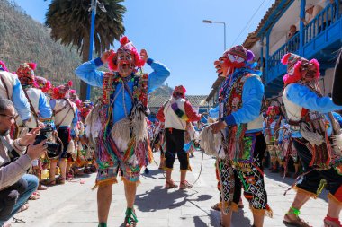 Geleneksel kostümlü dansçılar ve kalabalık Virgen del Carmen 'in şenliğini koreografilerle kutluyorlar. Temmuz 2023, Paucartambo. Cusco Peru.