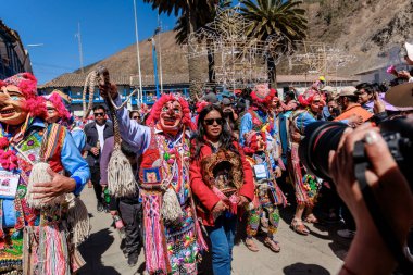 Geleneksel kostümlü dansçılar ve kalabalık Virgen del Carmen 'in şenliğini koreografilerle kutluyorlar. Temmuz 2023, Paucartambo. Cusco Peru.