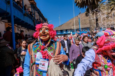 Geleneksel kostümlü dansçılar ve kalabalık Virgen del Carmen 'in şenliğini koreografilerle kutluyorlar. Temmuz 2023, Paucartambo. Cusco Peru.