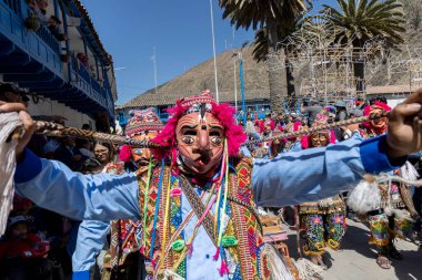 Geleneksel kostümlü dansçılar ve kalabalık Virgen del Carmen 'in şenliğini koreografilerle kutluyorlar. Temmuz 2023, Paucartambo. Cusco Peru.