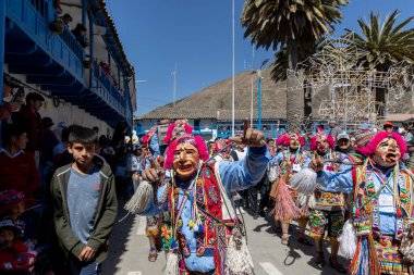 Geleneksel kostümlü dansçılar ve kalabalık Virgen del Carmen 'in şenliğini koreografilerle kutluyorlar. Temmuz 2023, Paucartambo. Cusco Peru.