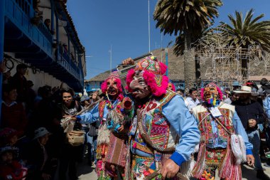 Geleneksel kostümlü dansçılar ve kalabalık Virgen del Carmen 'in şenliğini koreografilerle kutluyorlar. Temmuz 2023, Paucartambo. Cusco Peru.