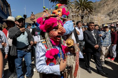 Geleneksel kostümlü dansçılar ve kalabalık Virgen del Carmen 'in şenliğini koreografilerle kutluyorlar. Temmuz 2023, Paucartambo. Cusco Peru.