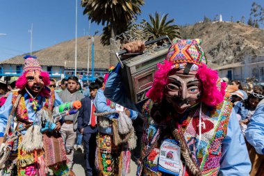 Geleneksel kostümlü dansçılar ve kalabalık Virgen del Carmen 'in şenliğini koreografilerle kutluyorlar. Temmuz 2023, Paucartambo. Cusco Peru.