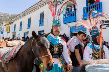 Geleneksel kostümlü dansçılar ve kalabalık Virgen del Carmen 'in şenliğini koreografilerle kutluyorlar. Temmuz 2023, Paucartambo. Cusco Peru.