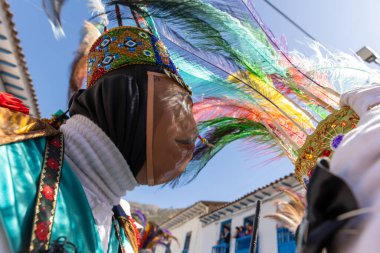 Geleneksel kostümlü dansçılar ve kalabalık Virgen del Carmen 'in şenliğini koreografilerle kutluyorlar. Temmuz 2023, Paucartambo. Cusco Peru.