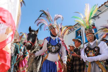 Geleneksel kostümlü dansçılar ve kalabalık Virgen del Carmen 'in şenliğini koreografilerle kutluyorlar. Temmuz 2023, Paucartambo. Cusco Peru.