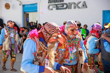 Geleneksel kostümlü dansçılar ve kalabalık Virgen del Carmen 'in şenliğini koreografilerle kutluyorlar. Temmuz 2023, Paucartambo. Cusco Peru.