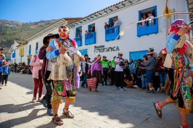 Geleneksel kostümlü dansçılar ve kalabalık Virgen del Carmen 'in şenliğini koreografilerle kutluyorlar. Temmuz 2023, Paucartambo. Cusco Peru.