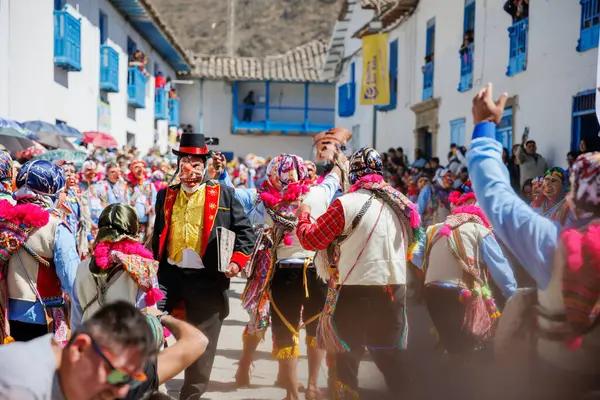 Geleneksel kostümlü dansçılar ve kalabalık Virgen del Carmen 'in şenliğini koreografilerle kutluyorlar. Temmuz 2023, Paucartambo. Cusco Peru.