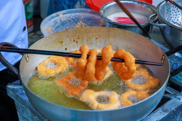 stock image Peruvian Picarones, a delicious dessert made of wheat flour mixed with pumpkin and, sometimes, sweet potato, bathed in chancaca honey. It is a traditional dish of Peruvian gastronomy.