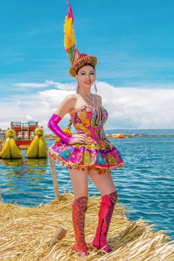 Peru 'nun Puno kentindeki Uros ve Titicaca Gölü adasında, Candelaria festivalinin tipik kostümünü giymiş güzel bir dansçı.